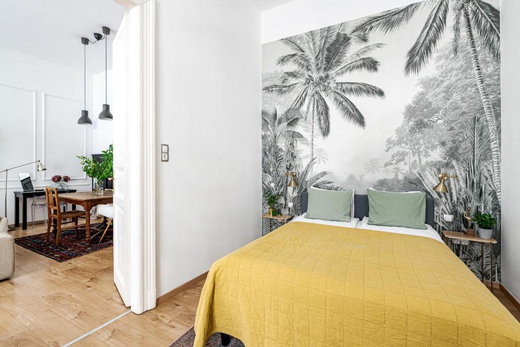 a bedroom with a yellow bed and palm trees mural at Hidden gem in the very heart of the city in Budapest