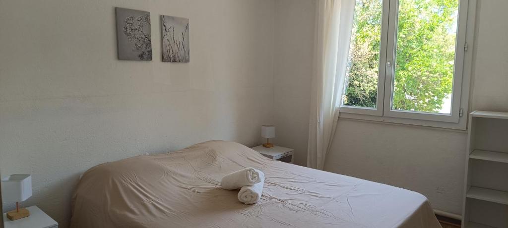 a white bedroom with a bed with towels on it at Havre de paix près d'Avignon in Bédarrides