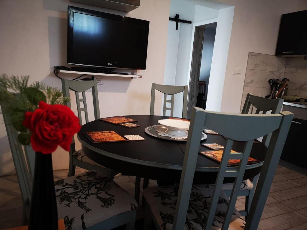 a dining room table with chairs and a television at Apartma Oreh Vila Ziba in Bohinj