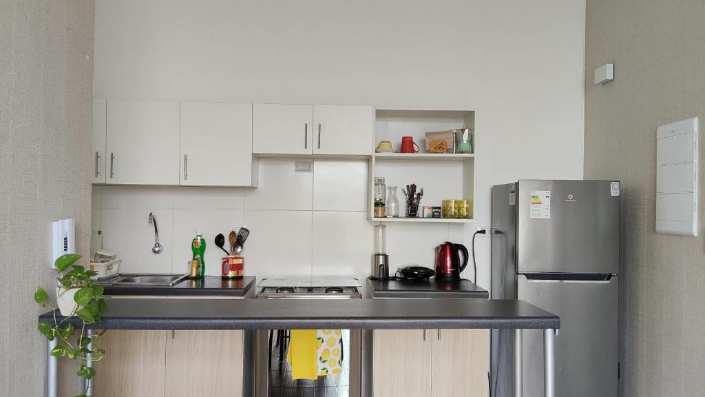 eine Küche mit weißen Schränken und einem Edelstahlkühlschrank in der Unterkunft Refugio Custodia 2 vista a montaña in Tarapoto