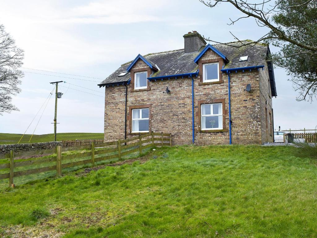 a stone house on a hill with a fence at Brick Cottage 2-Uk13675 in Palnure