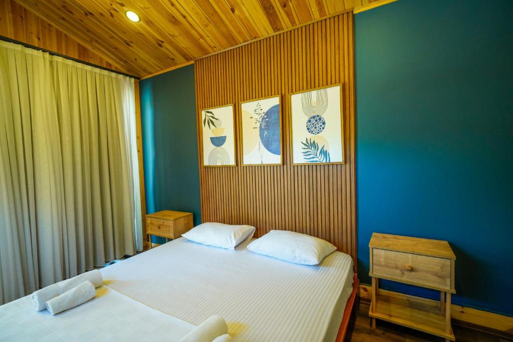 a bedroom with two beds and a blue wall at Marimare Beach & Bungalow in Marmaris