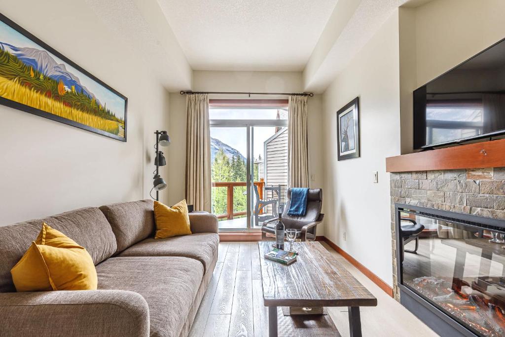 a living room with a couch and a fireplace at Mountain Luxe in Canmore