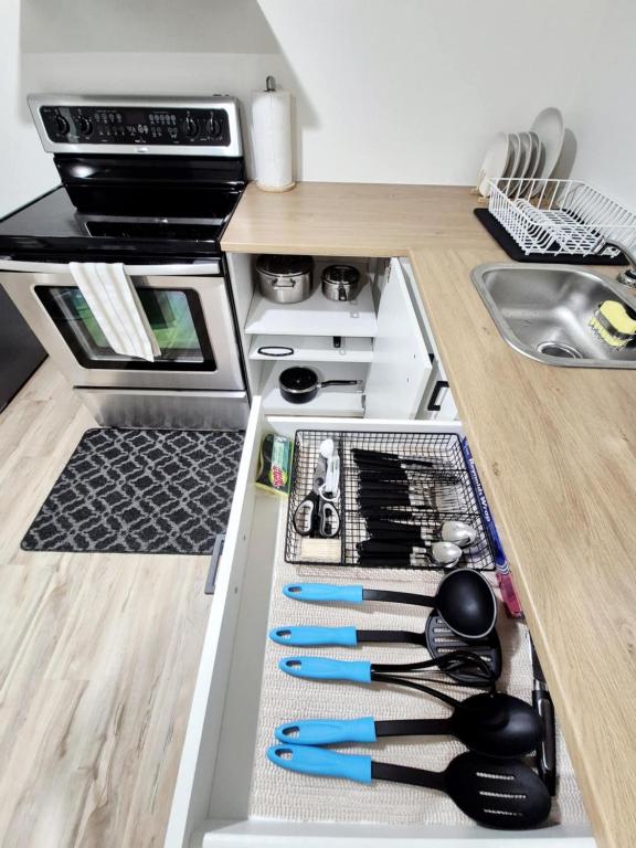 a kitchen with an open drawer with cooking utensils at Cozy Private Bachelor Unit King Size bed in Riverview