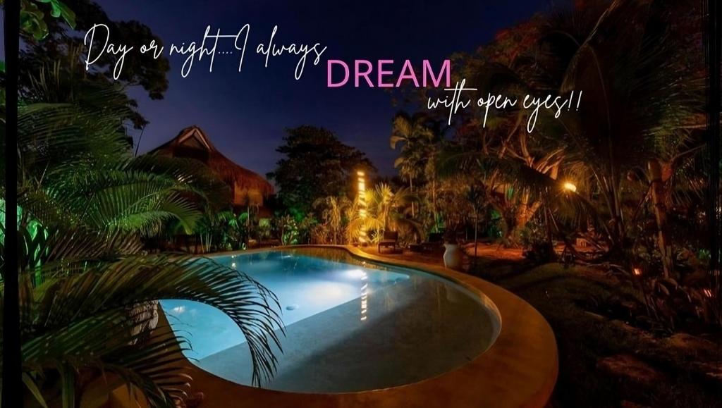 a picture of a swimming pool at night with a dream with our wish at Zamunda Garden View in Tulum