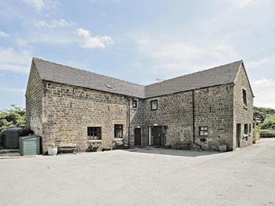 a large brick building with a large roof at The Barn - B6206A in Onecote