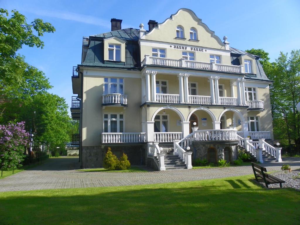 a large white house with a balcony at Jasny Pałac in Zakopane