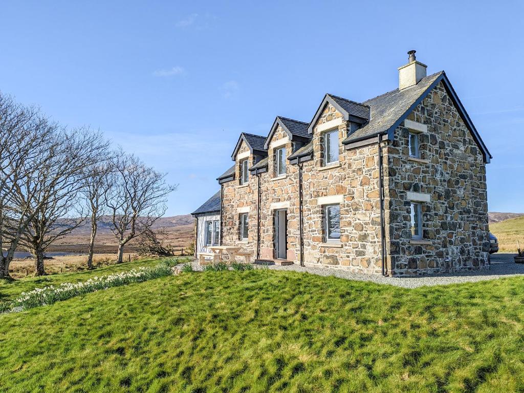 an old stone house on a grassy hill at The Beach House in Dunvegan
