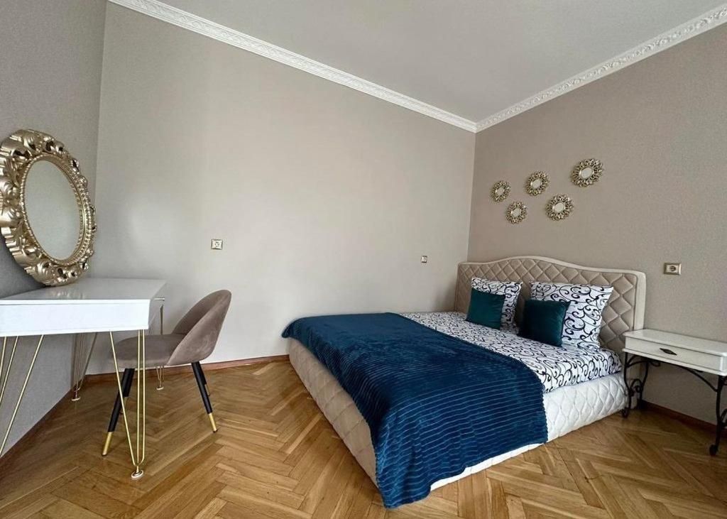 una camera da letto con un letto con lenzuola blu e uno specchio di Daily tovar a Tashkent