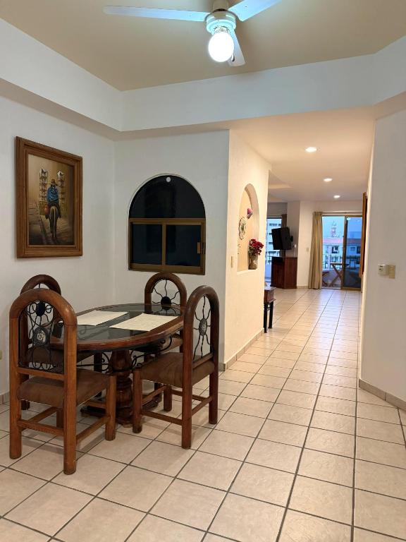 a dining room with a table and chairs on a tile floor at Casa Olas in Puerto Vallarta