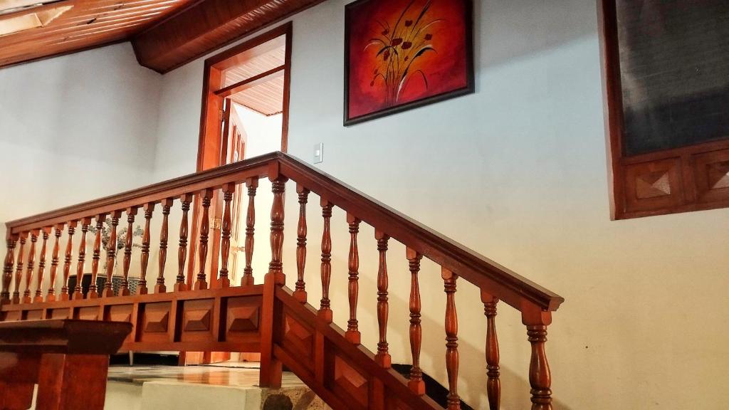 - un escalier en bois dans une maison avec une photo sur le mur dans l'établissement Hotel Mamma Mia, à Duitama