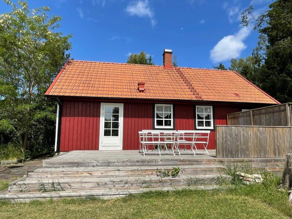 ein rotes Haus mit Tischen und Stühlen davor in der Unterkunft Semi-Detached House 210m from Beach in Fågelmara
