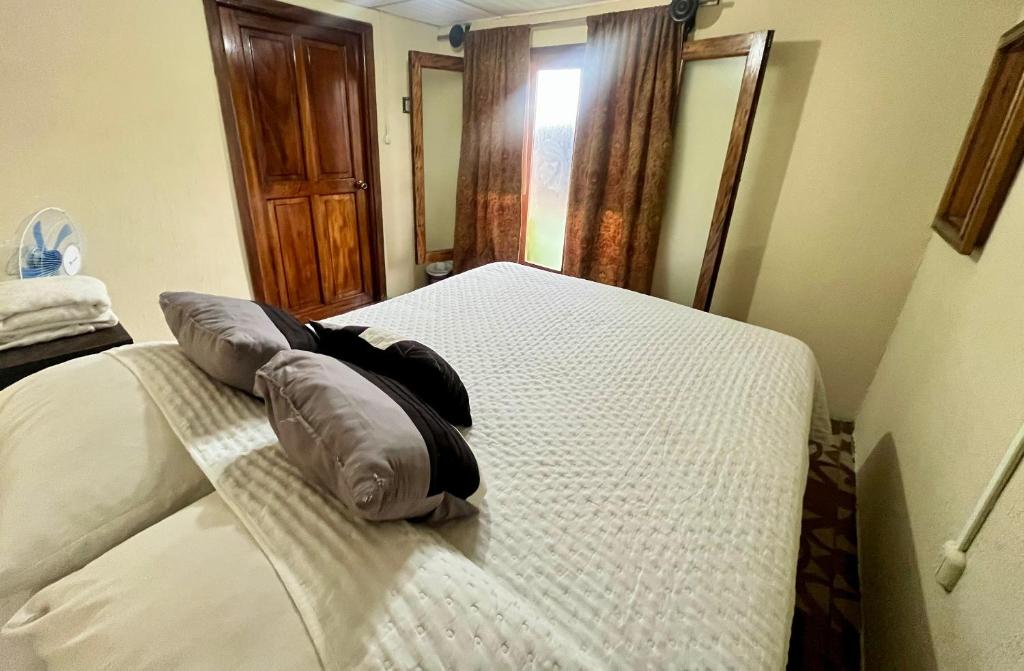 a bedroom with a bed with a pillow on it at Jireh guesthouse in Antigua Guatemala