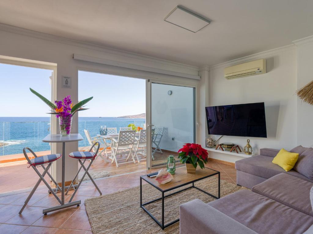 un salon avec un canapé et une télévision dans l'établissement Apartment in Tufia with Oceanfront Terrace, à Telde