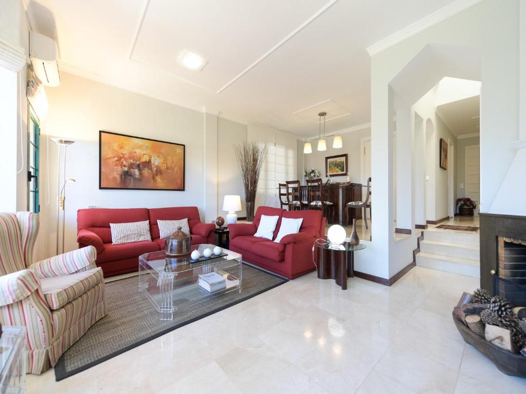 ein Wohnzimmer mit roten Sofas und einem Kamin in der Unterkunft House in Santa Brígida with Sea & Mountain Views in Santa Brígida