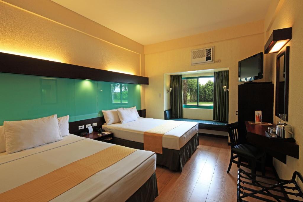 Postel nebo postele na pokoji v ubytování Microtel by Wyndham Cabanatuan