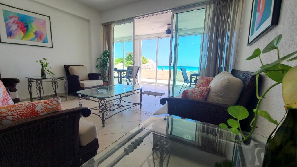 een woonkamer met uitzicht op de oceaan bij Beach Patio Paradise in Cancun
