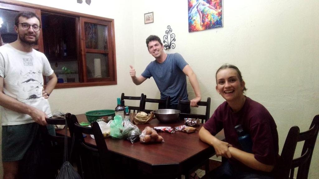a group of three people standing around a table at Jireh guesthouse in Antigua Guatemala