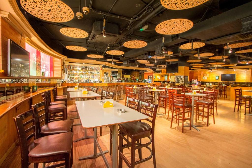 un ristorante con tavoli e sedie e un bar di Horizon Manor Hotel a Doha