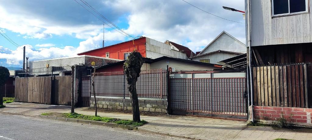 una recinzione di fronte a una casa con un edificio di Casa interior 2 pisos, 3 hab, 1 cama 2 plazas, 3 camas 1 plaza y 1 litera a Laja