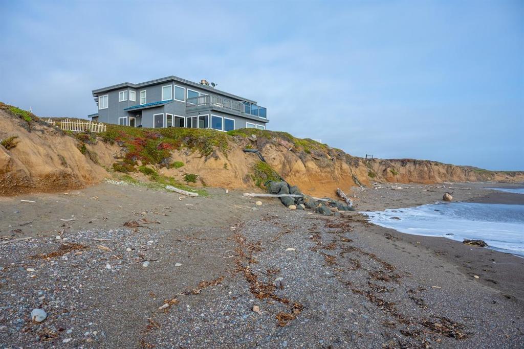 a house on top of a cliff next to the ocean at Blue Haven-Oceanfront Stay Near Cambria & Beaches in San Simeon