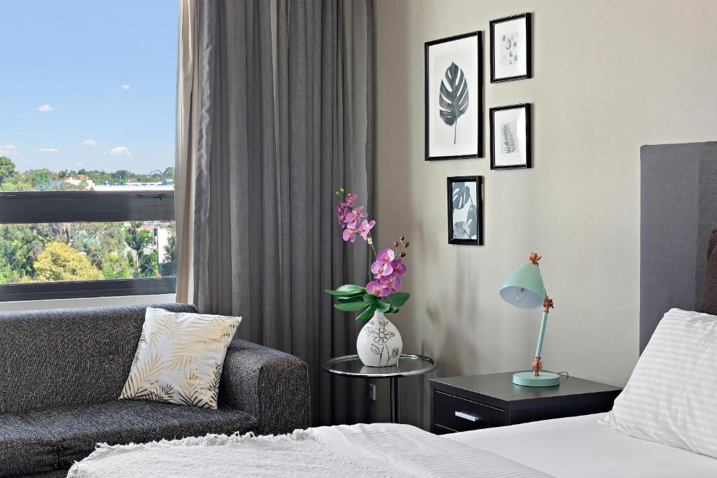 a bedroom with a bed and a couch and a window at 1 Valentine Ave in Sydney