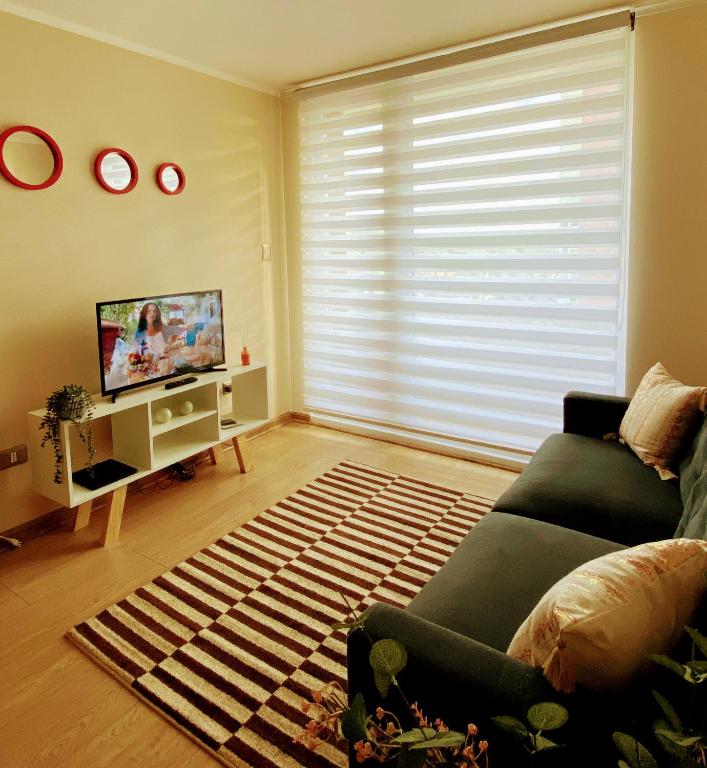 a living room with a couch and a television at Departamento 2 habitaciones in Temuco