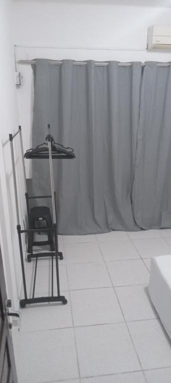 Una mesa y una silla en una habitación con una cortina. en Apartamento com quarto e frigobar, en Santarém