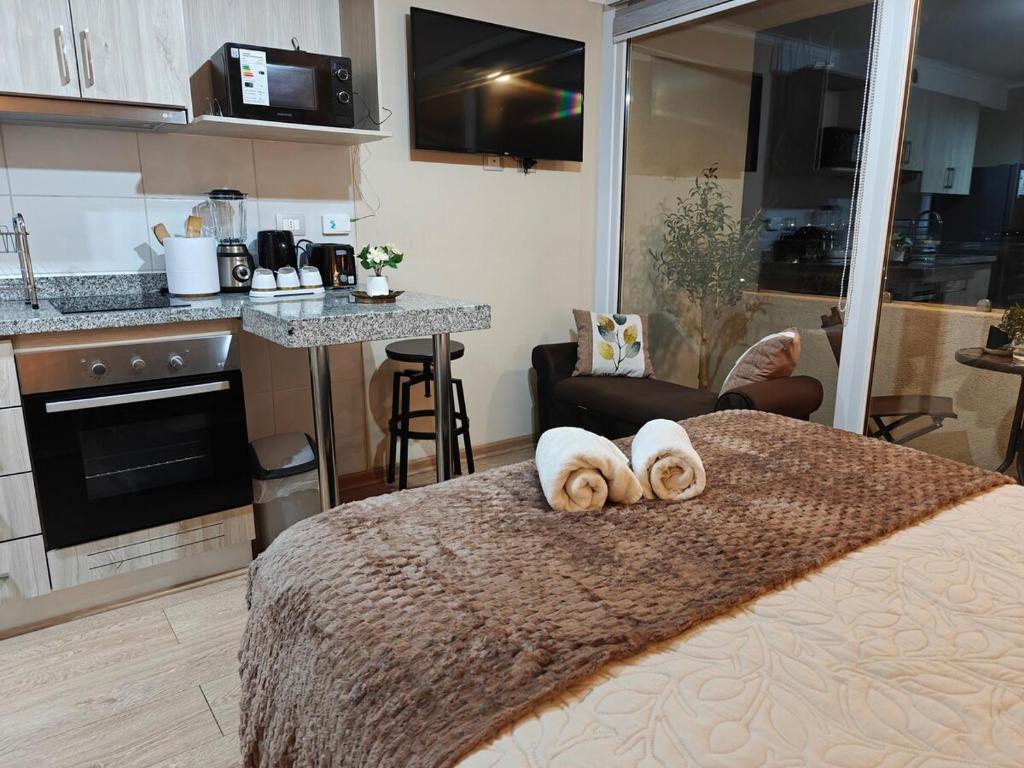 a bedroom with a bed with two towels on it at Depto centro de chillan con estacionamiento in Chillán