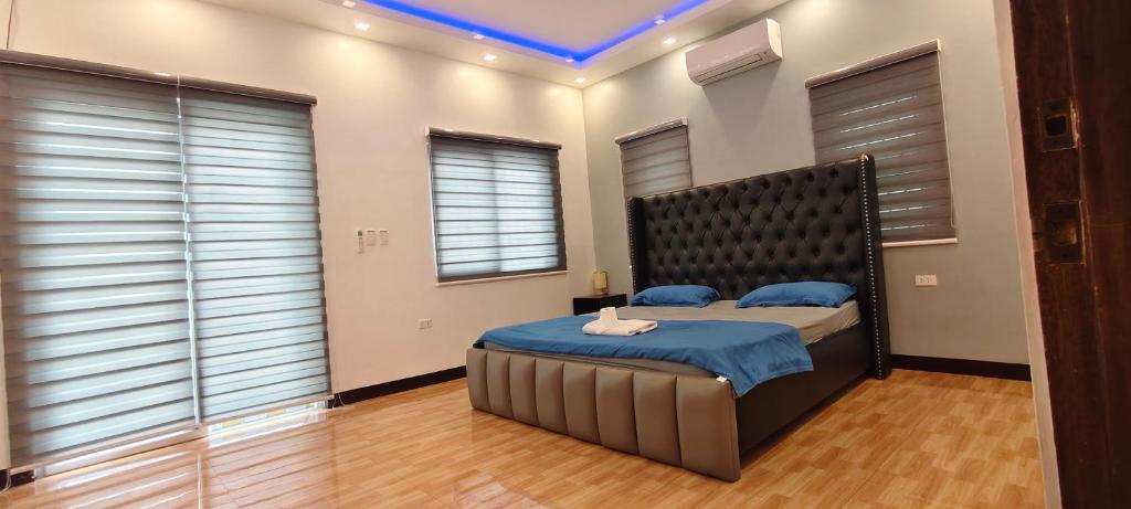a bedroom with a large bed with a black headboard at M3 Private Villa in Angeles