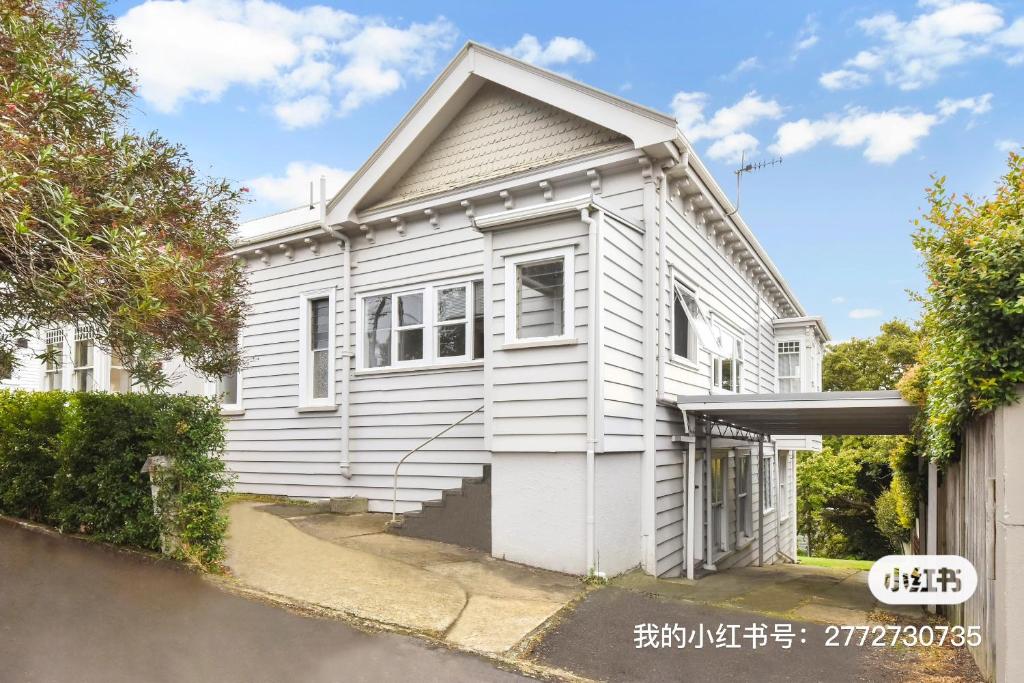 a white house with a garage at Parnell City Haven Same Price for 1 to 6 Guests Villa with Full Kitchen in Auckland