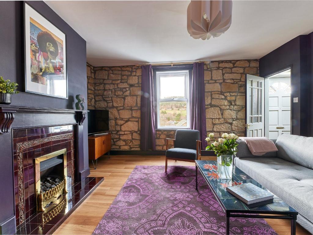 a living room with a couch and a fireplace at Alt-Na-Craig in Rothbury