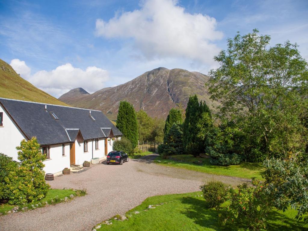 una casa en las montañas con un coche aparcado en la entrada en Bidean Cottage - Uk41933, en Glencoe