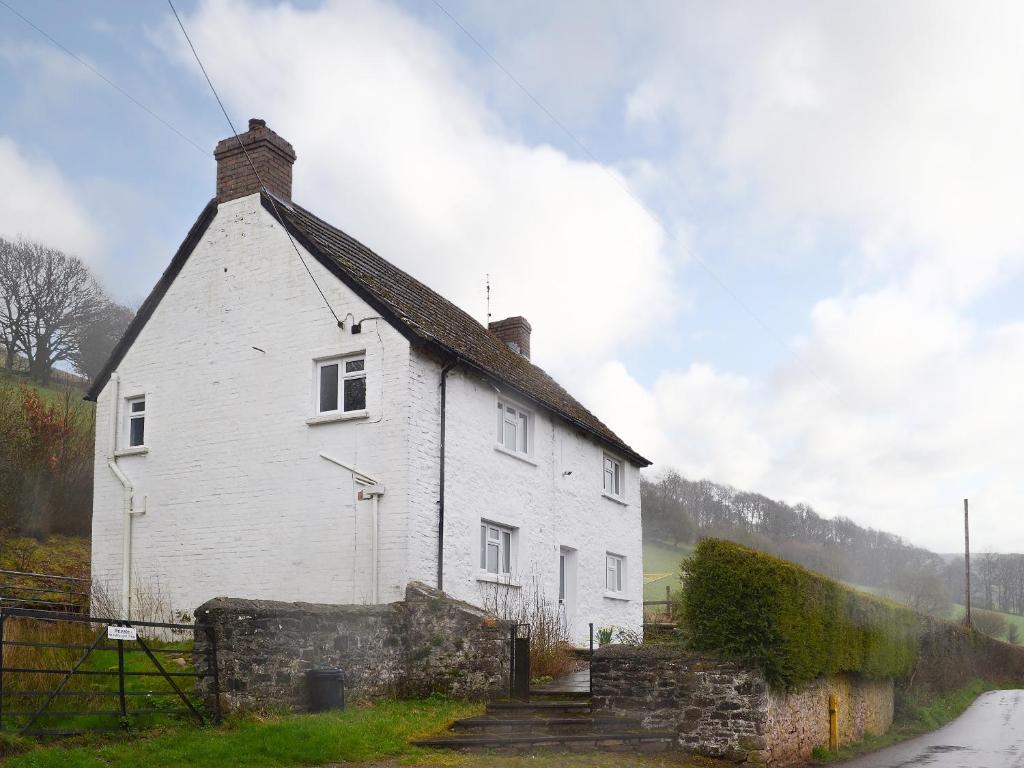 a white house with a chimney on top of it at Upper Ffinnant in Aber-Brân