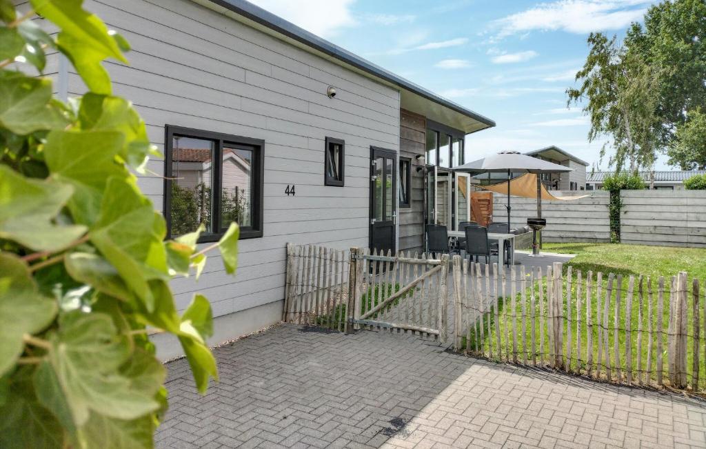 a white house with a fence and a patio at 2 Bedroom Cozy Home In Sint-Annaland in Sint Annaland