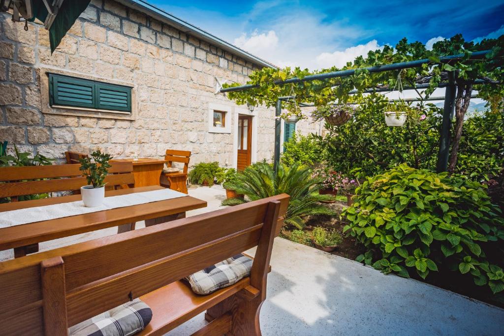 une terrasse avec un banc en bois devant un bâtiment dans l'établissement Kuća Cvjetković, à Gruda