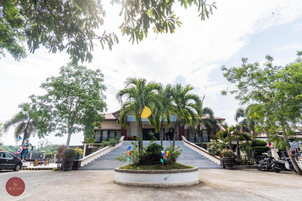 ein Gebäude mit Palmen davor in der Unterkunft Quezon Premier Hotel - Candelaria in Candelaria