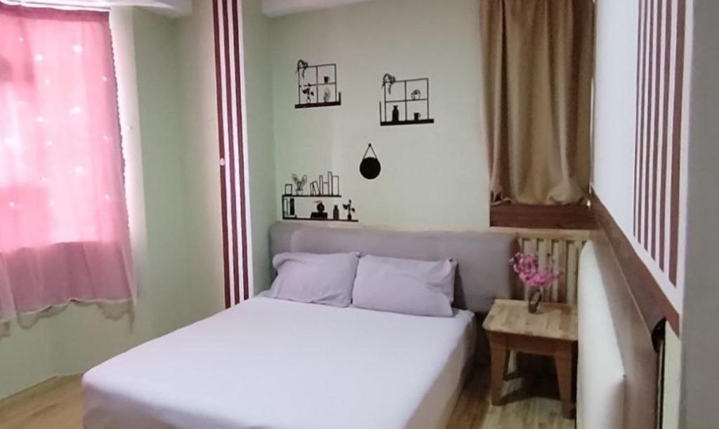 Un dormitorio pequeño con una cama blanca y una ventana. en Driver COUPLE room Genting highland, en Genting Highlands