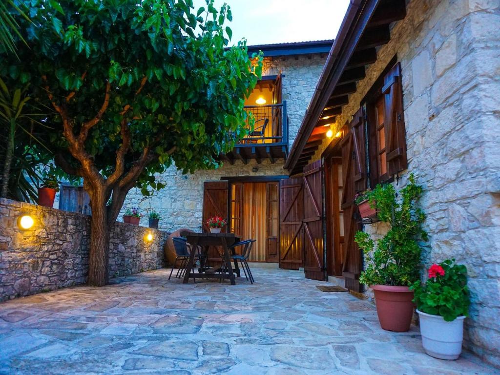 eine Außenterrasse mit einem Tisch und einem Baum in der Unterkunft Omodos Village Houses in Omodos