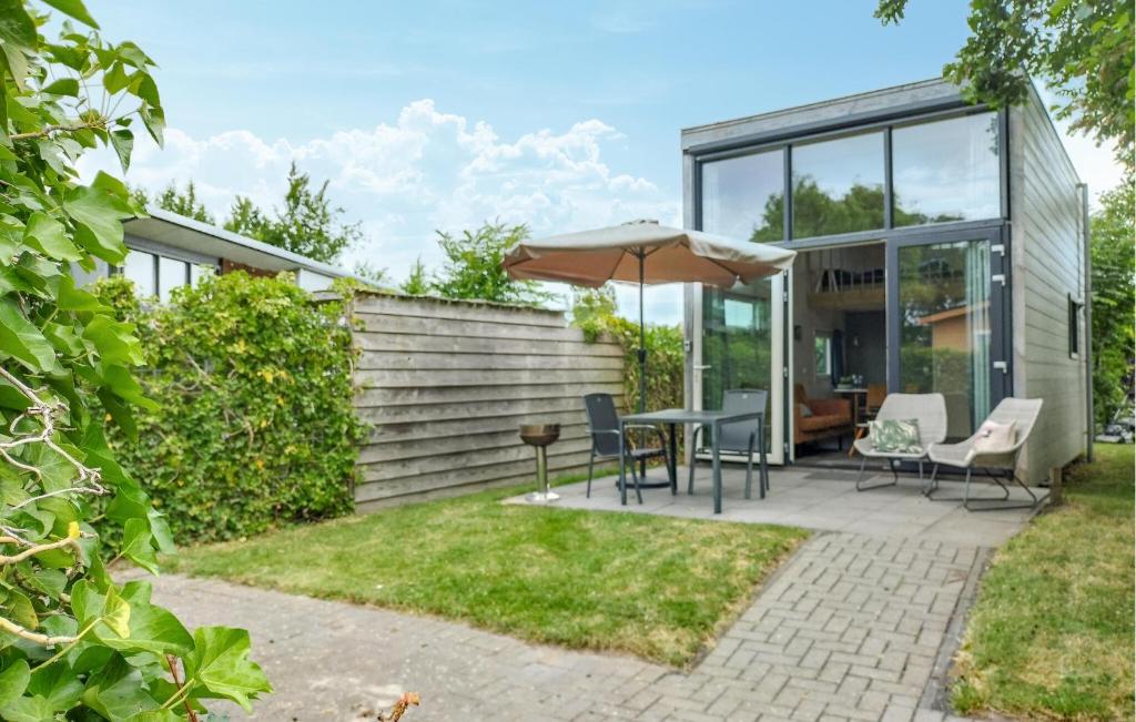 a patio with a table and chairs and an umbrella at One-Bedroom Holiday Home In Sint-Annaland in Sint Annaland