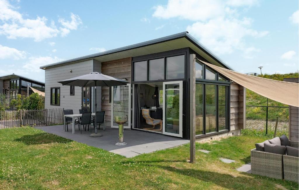 a small house with a table and an umbrella at Cozy Home In Sint-Annaland With Wifi in Sint Annaland