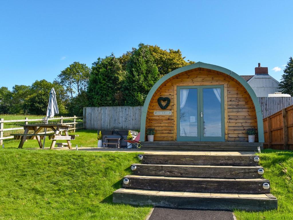 a small cabin in a field with a picnic table at Jacob's Den - Uk40976 in Felindre