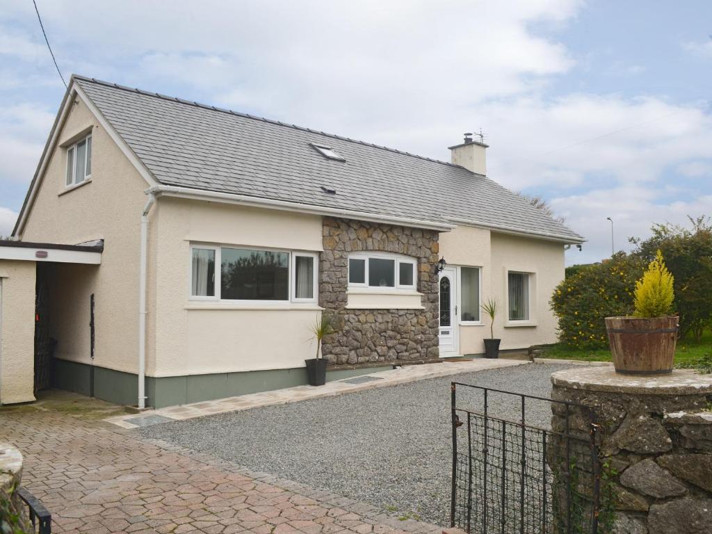a house with a gravel driveway in front of it at Rosedale in Benllech