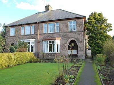 a large brick house with a pathway in front of it at Melville in Bakewell