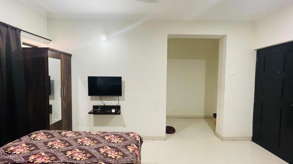 a room with a bed and a tv on a wall at Studio flats in Candolim in Candolim
