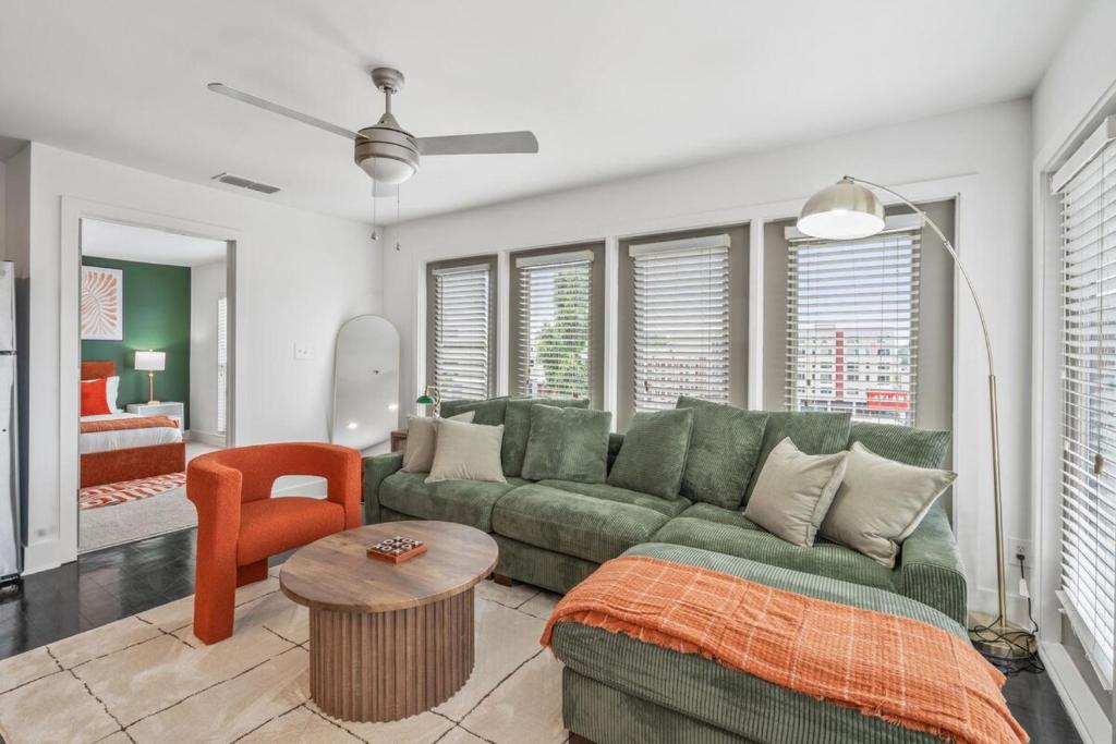 a living room with a green couch and a table at Reynoldstown Lux 2BR, Rooftop Deck, Near Beltline & Downtown, Free Parking in Atlanta