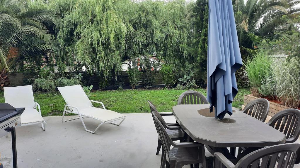 une table et des chaises avec un parasol sur une terrasse dans l'établissement Apparemment avec JARDIN idéalement située, à Mouguerre