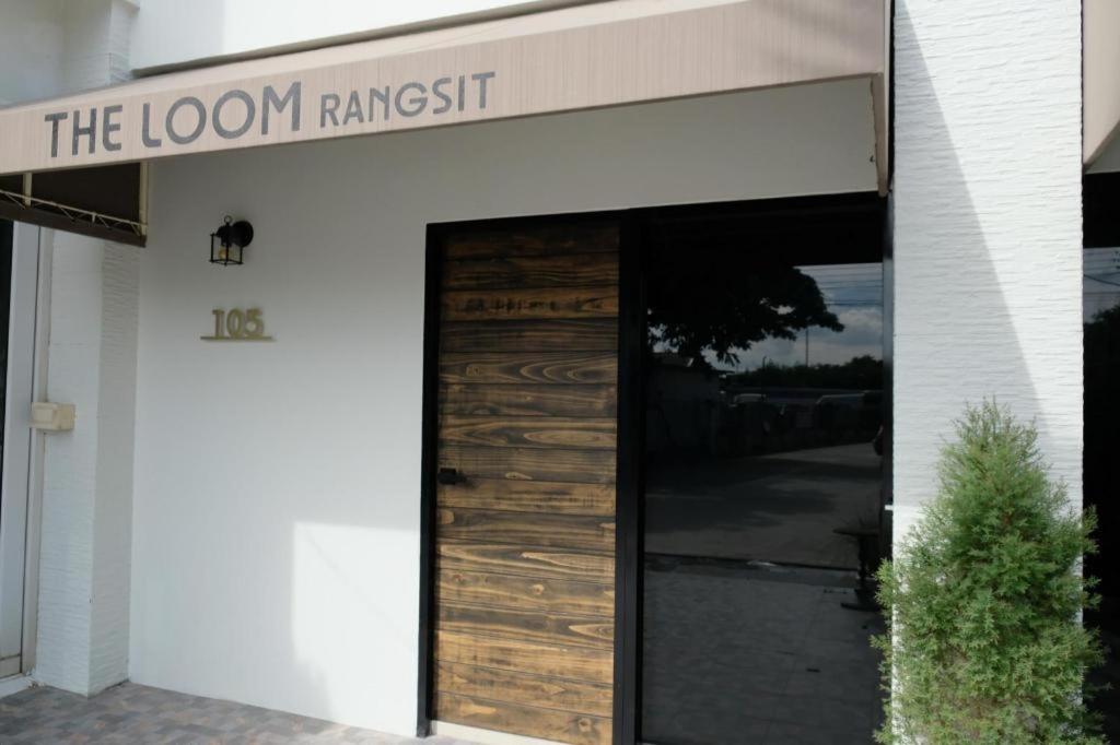 eine Tür zu einem Zimmer mit einem Schild mit der Aufschrift „Loom Ranch“ in der Unterkunft The Loom Rangsit in Ban Lam Phak Kut