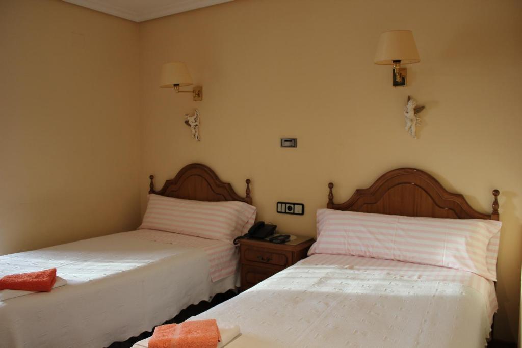 two beds sitting next to each other in a room at Hostal Casa Perico in Larraga