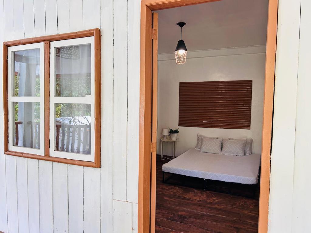 a bed in a room with a window and a bed sidx sidx sidx at Mountain River Lodge Room in Daraitan Tanay Rizal Philippines in Laiban